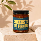 Candle with text "Cheers to the Fiances. They will be telling the story all night."