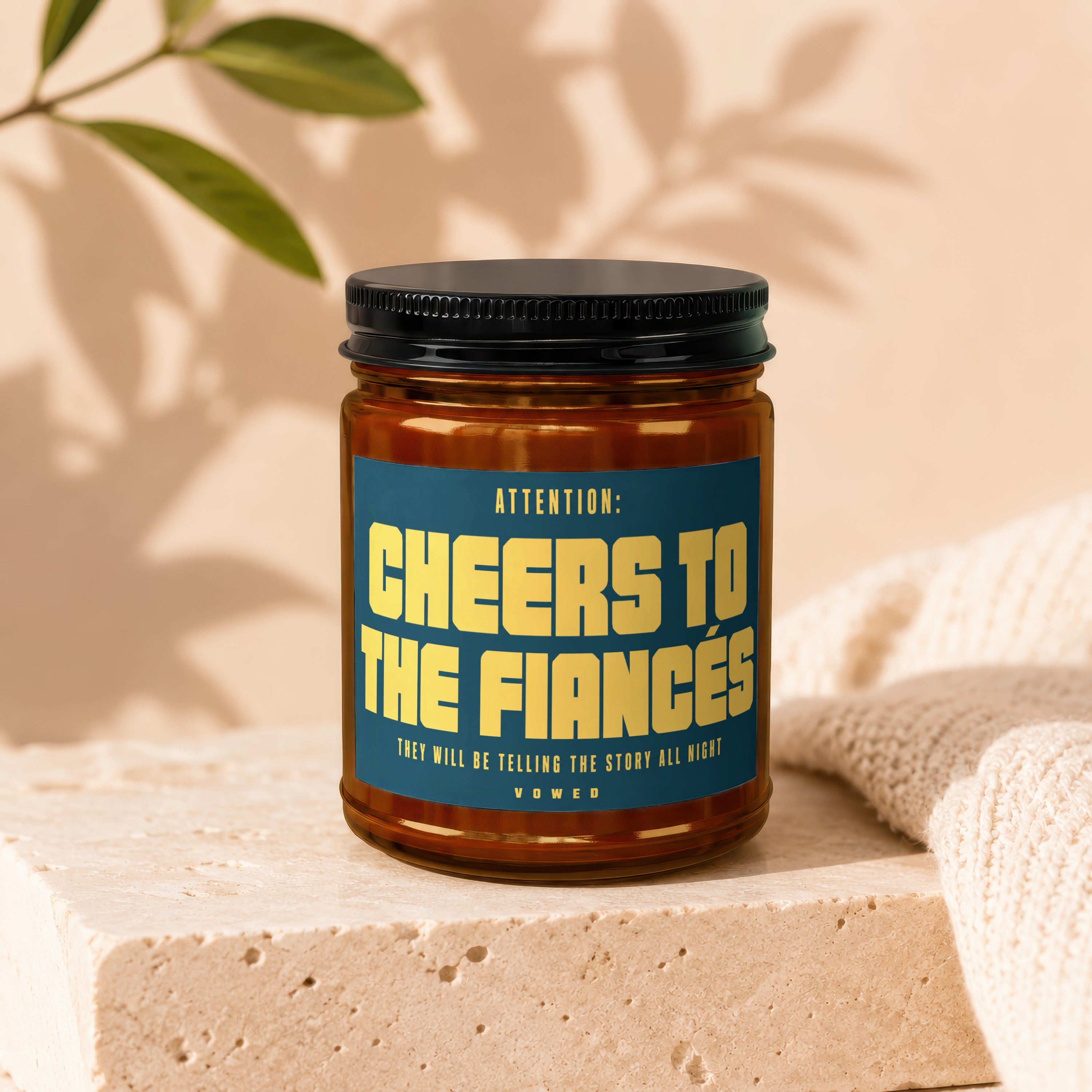 Candle with text "Cheers to the Fiances. They will be telling the story all night."
