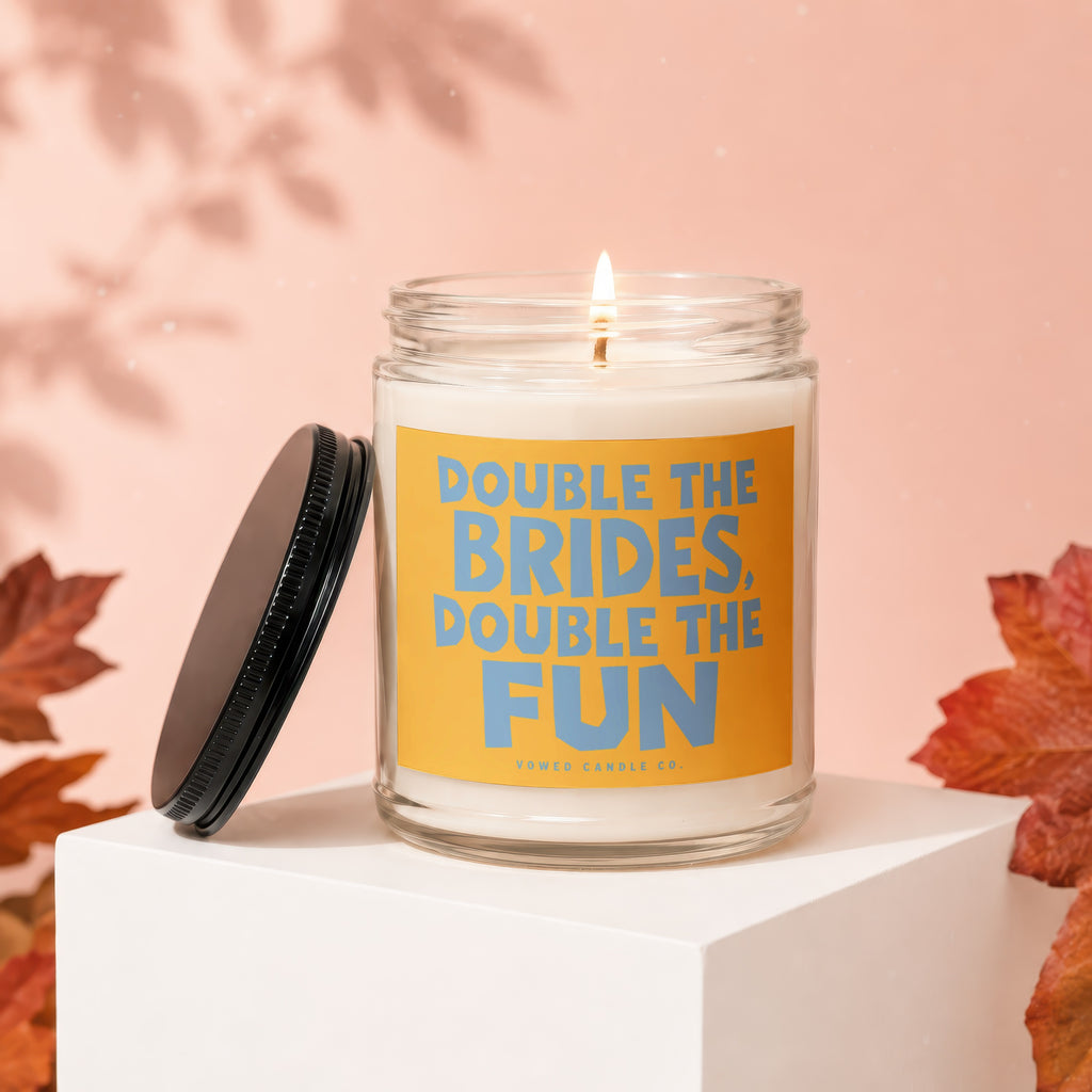 Glass jar candle with orange label reading "Double the Brides, Double the Fun".