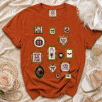 Orange t-shirt with vintage-style frames of Halloween and bridal motifs.