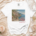 White t-shirt with print of Amalfi Coast town, champagne, and text.