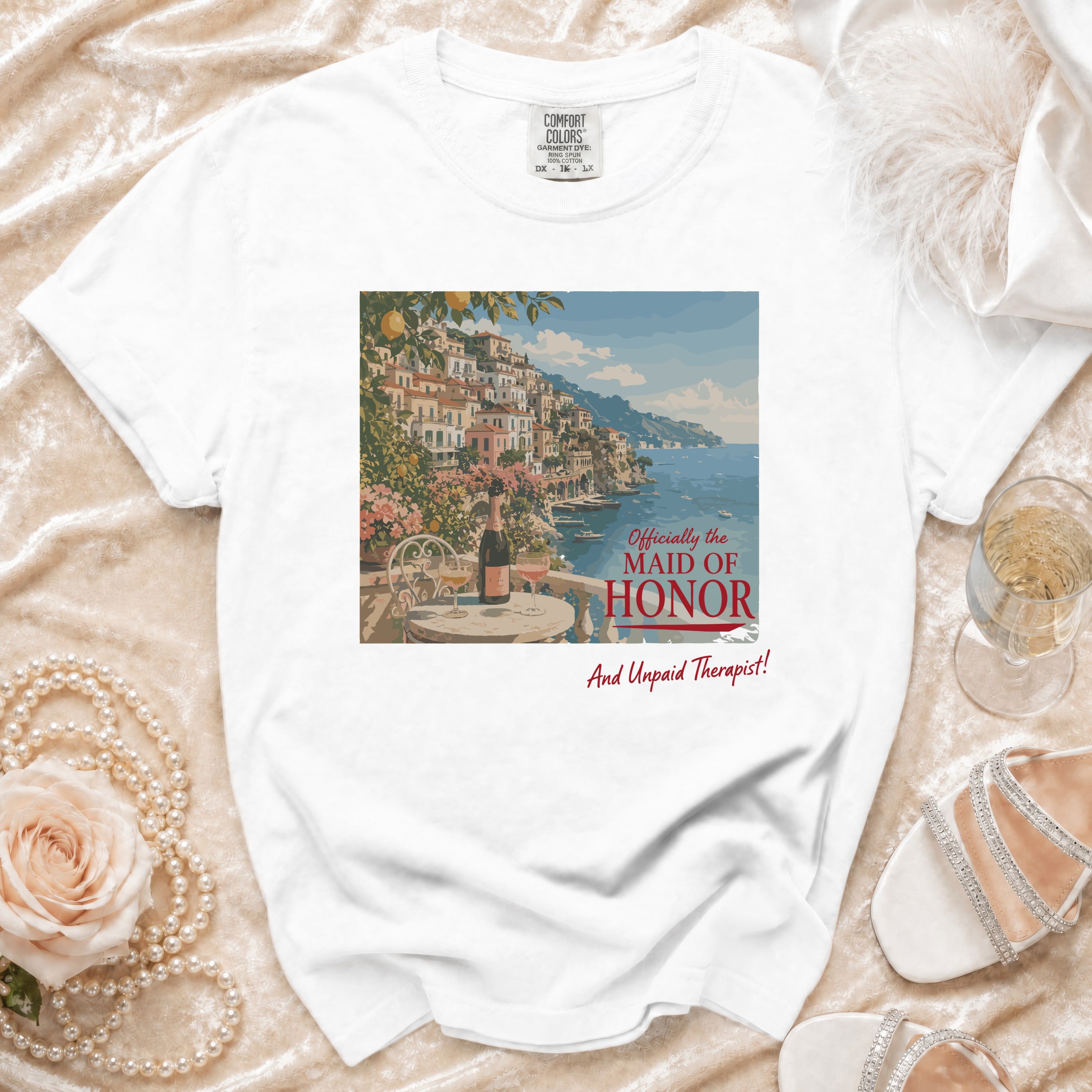 White t-shirt with print of Amalfi Coast town, champagne, and text.