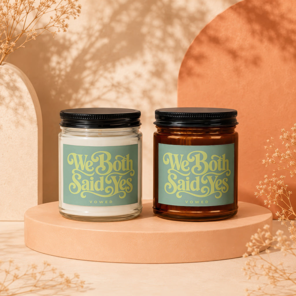Two Vowed candles with "We Both Said Yes" text on a terracotta pedestal.