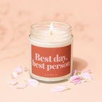 Candle with text "Best day, best person" and "VOWED", surrounded by flower petals.
