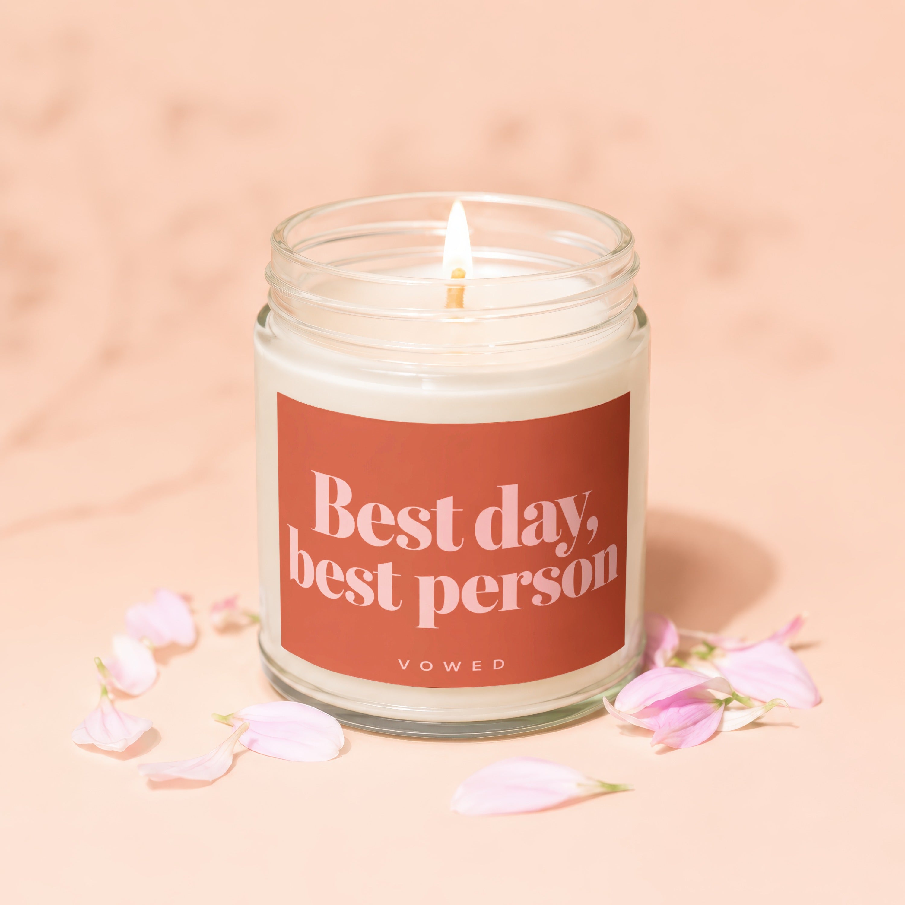 Candle with text "Best day, best person" and "VOWED", surrounded by flower petals.