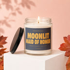 Glass jar candle labeled "MOONLIT MAID OF HONOR" with burning wick.