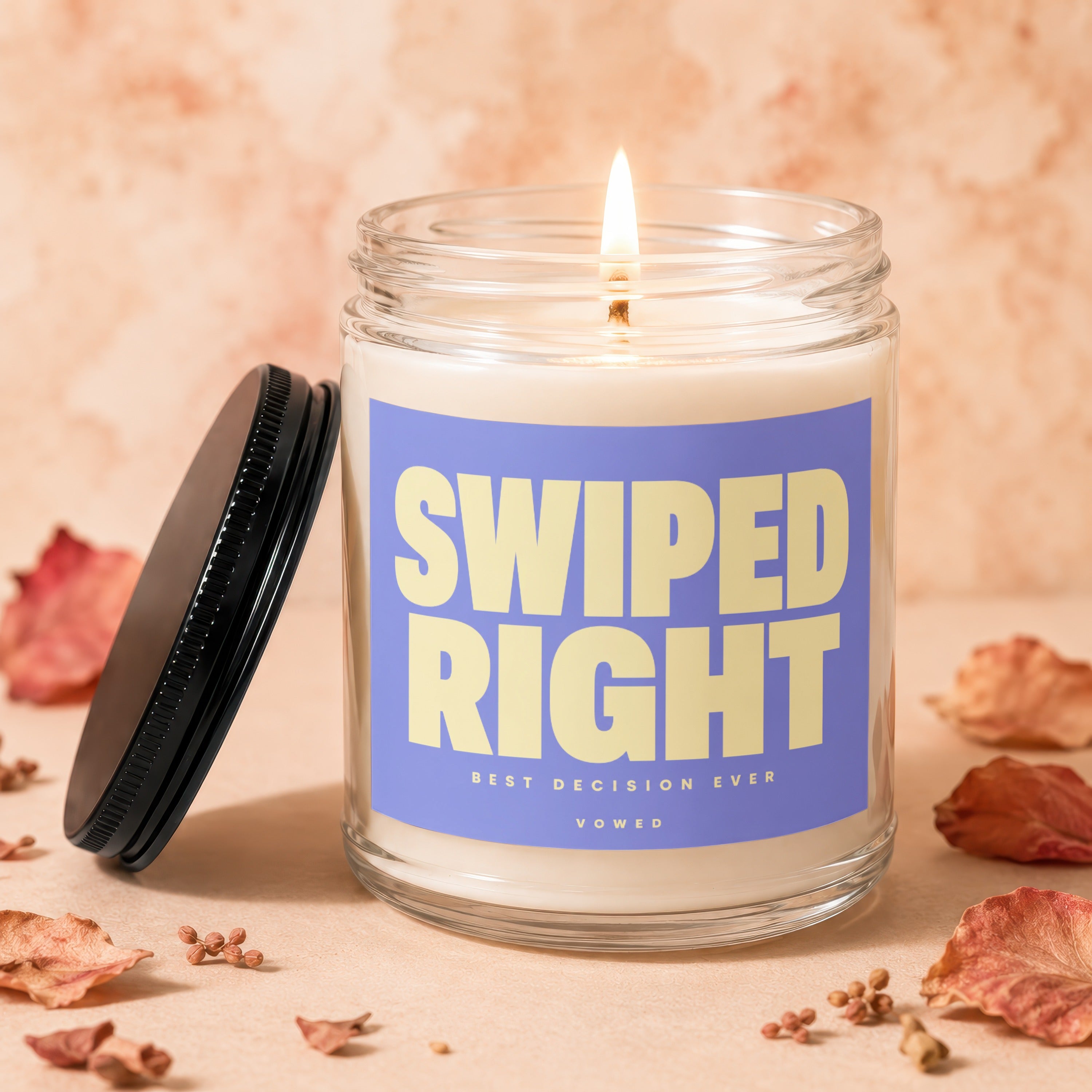 Glass candle with lit wick and label reading "SWIPED RIGHT BEST DECISION EVER VOWED".