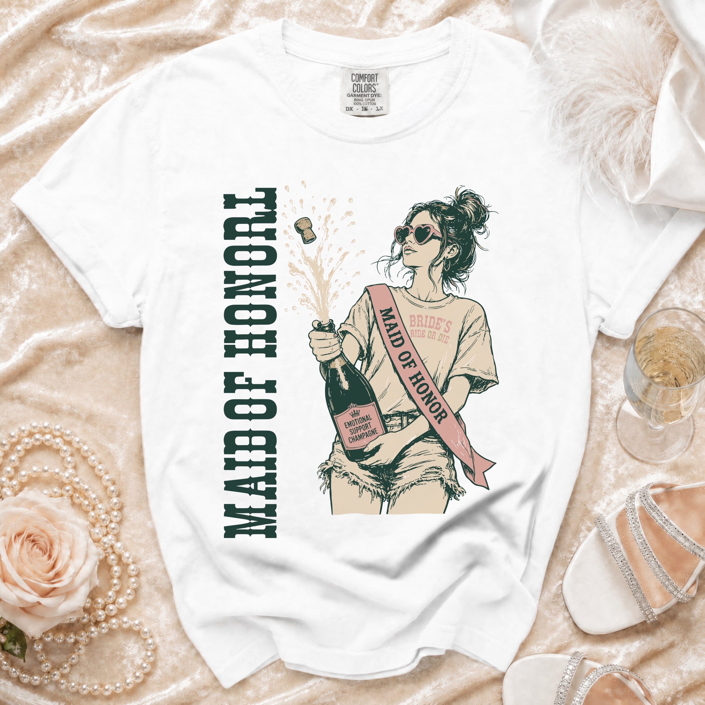 White t-shirt with graphic of woman popping champagne, "Maid of Honor" text.