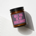 Candle in amber jar with black lid, "Will you be my bridesmaid?" in pink text.