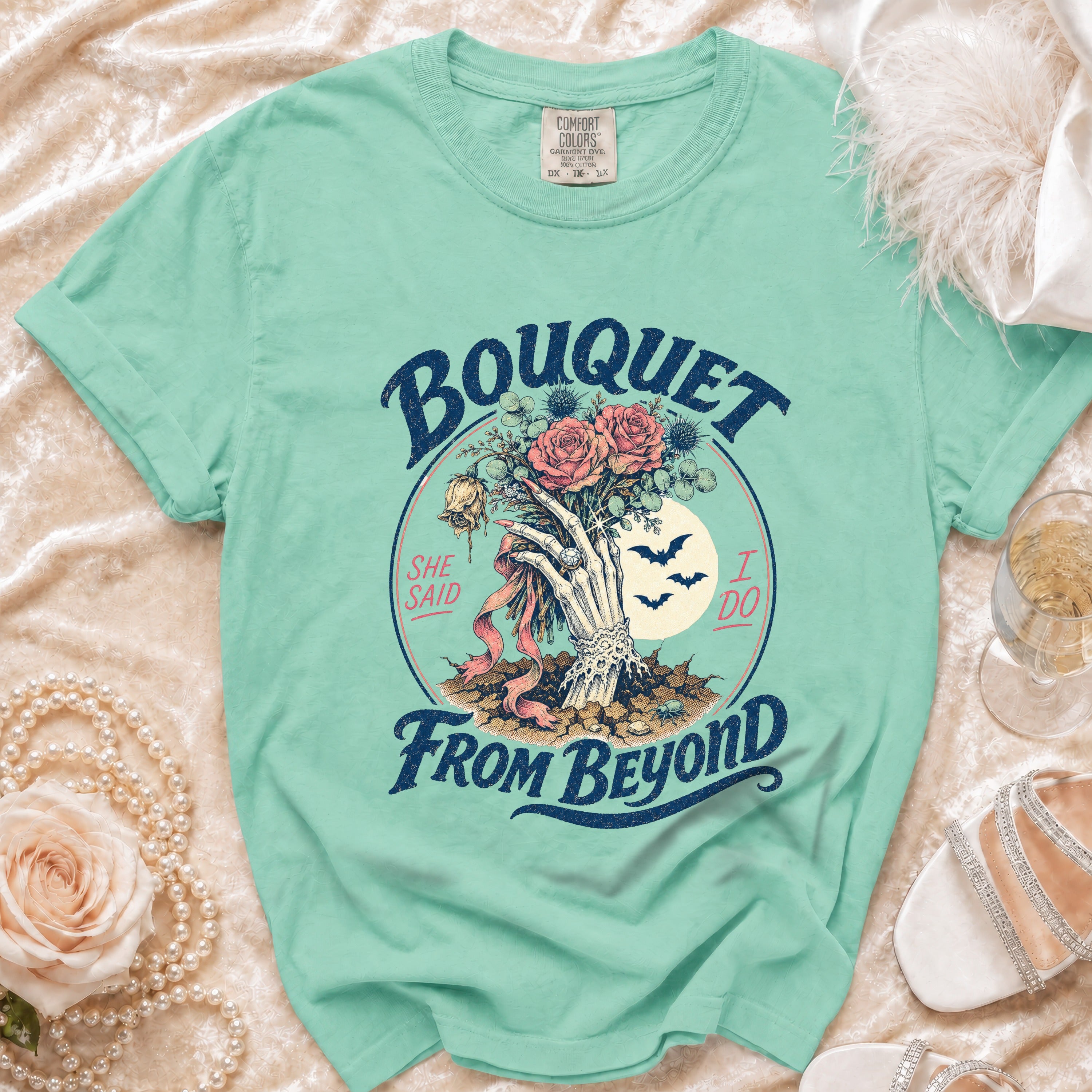 Mint green t-shirt with skeleton hand holding Bouquet From Beyond text.