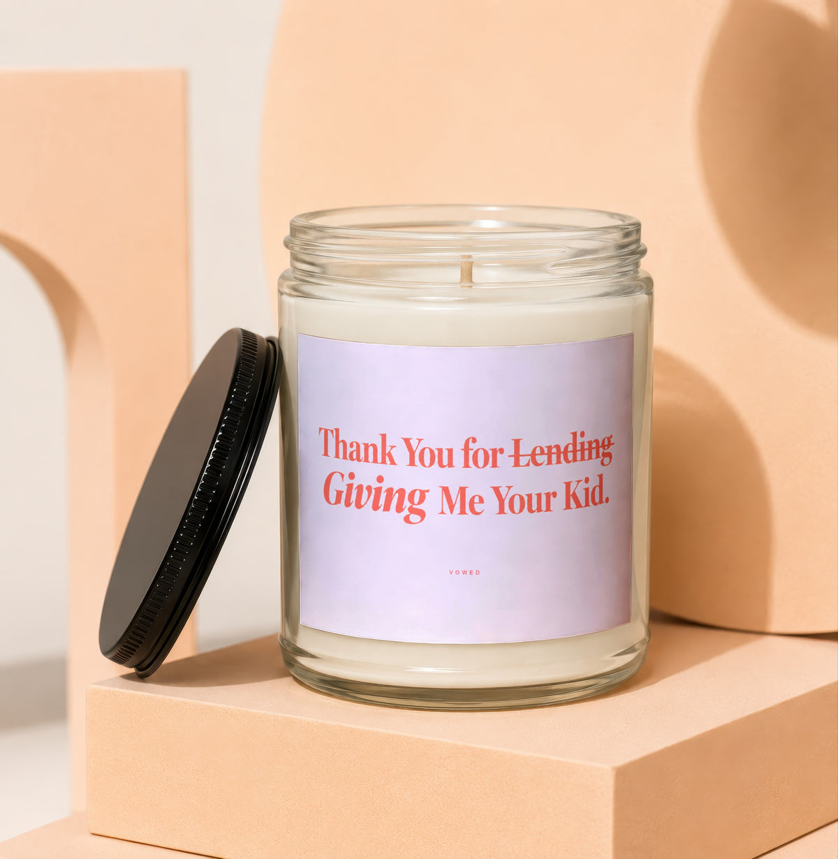 Glass candle with black lid and label reading "Thank You for Lending Giving Me Your Kid."