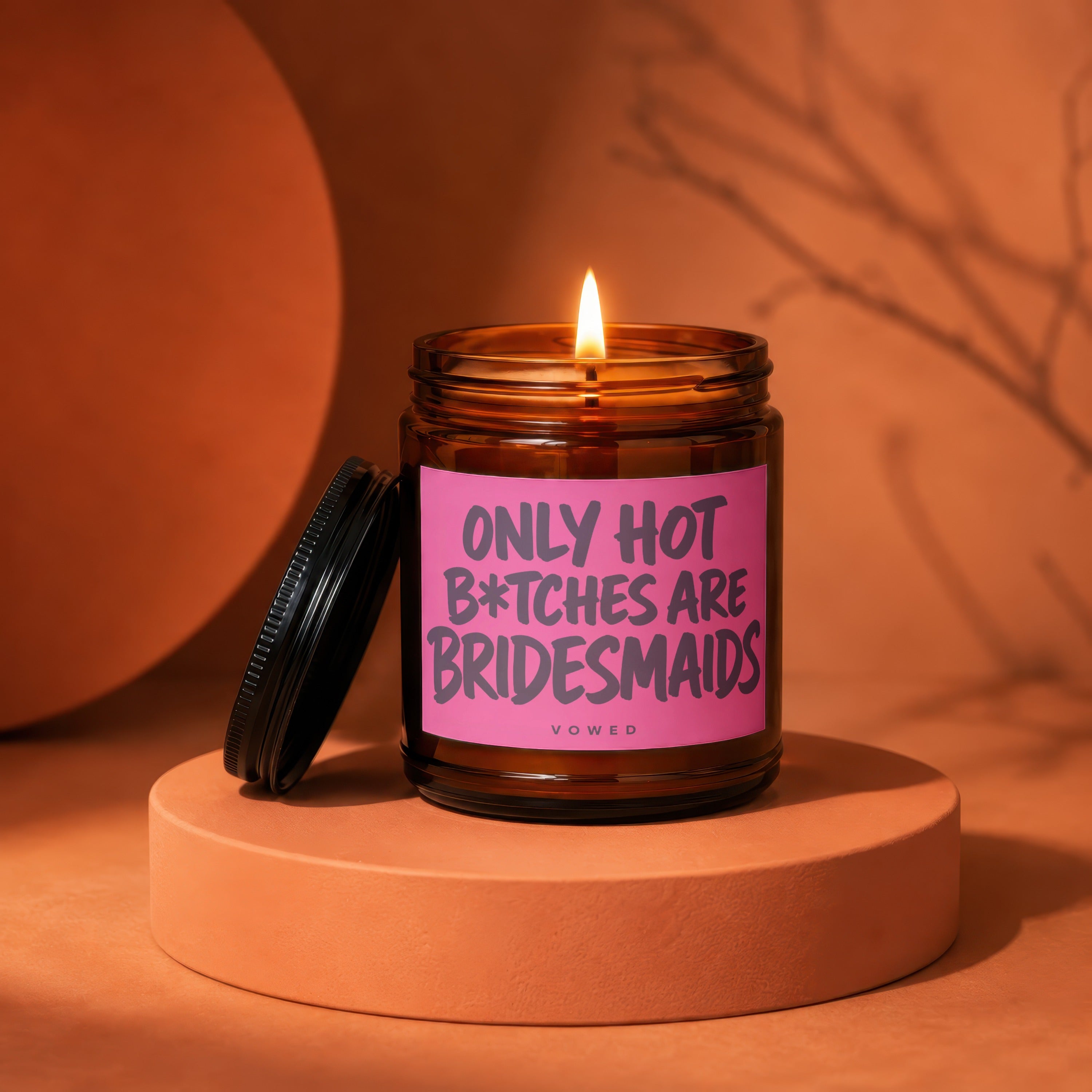 Glass candle with pink label reading "Only Hot B*tches are Bridesmaids"