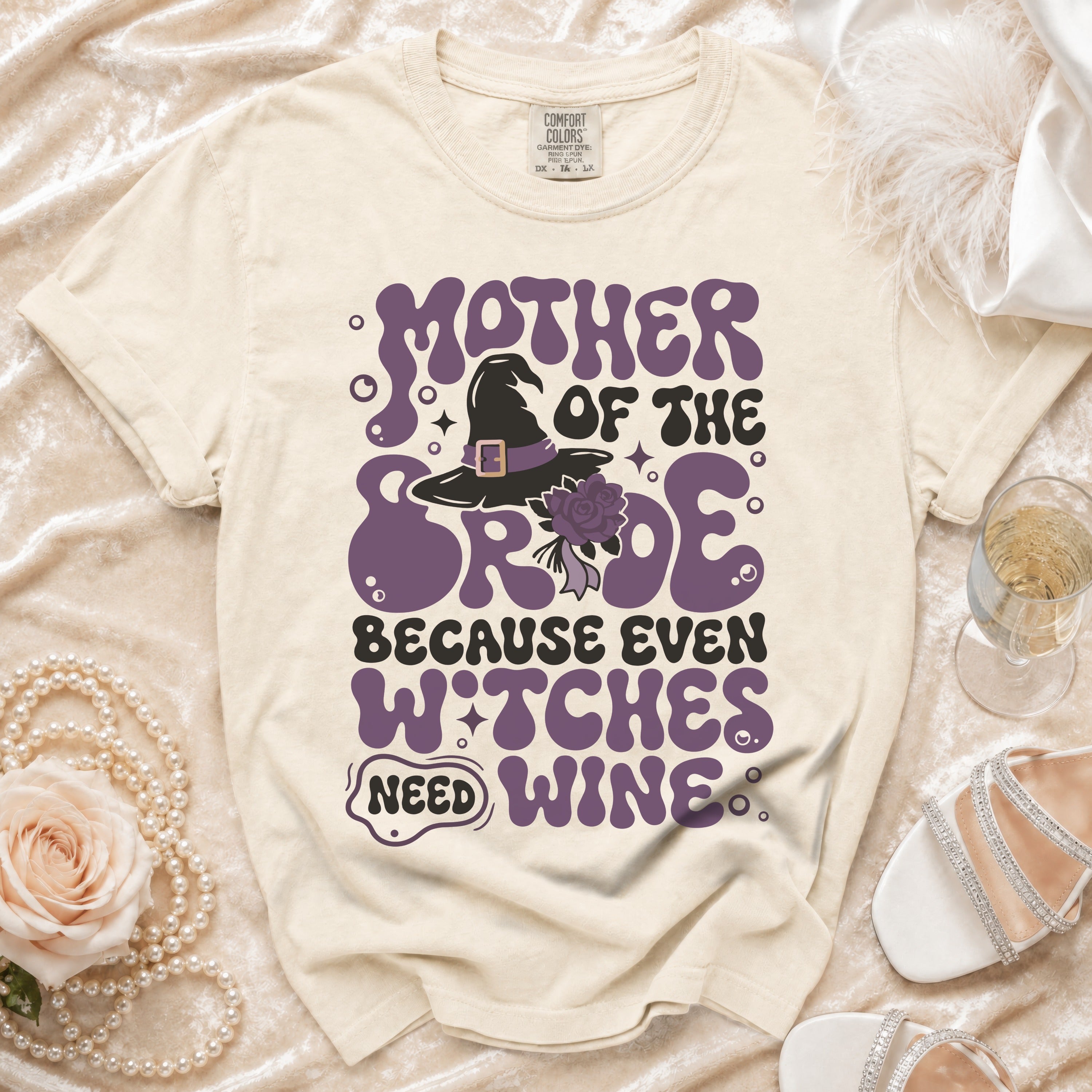 Cream t-shirt with "Mother of the Bride Because Even Witches Need Wine" graphic.