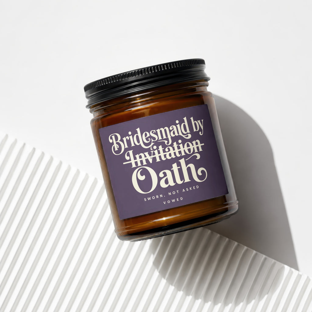 Amber glass candle with a purple label reading "Bridesmaid by Invitation Oath".