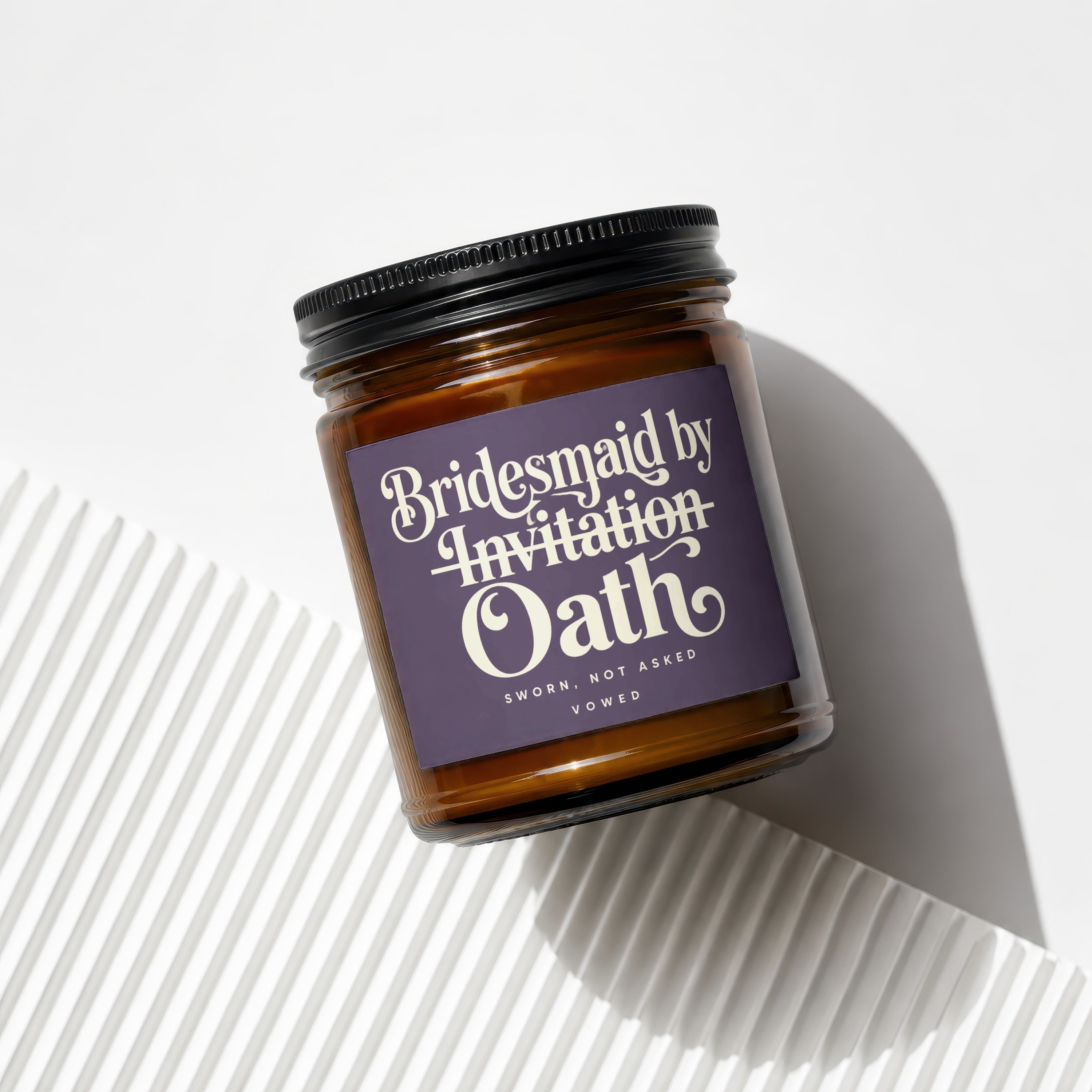 Amber glass candle with a purple label reading "Bridesmaid by Invitation Oath".