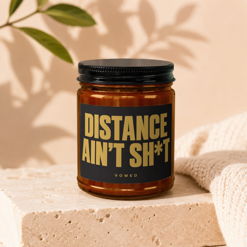 Brown amber jar candle with black label reading "DISTANCE AIN'T SH*T" and "vowed".