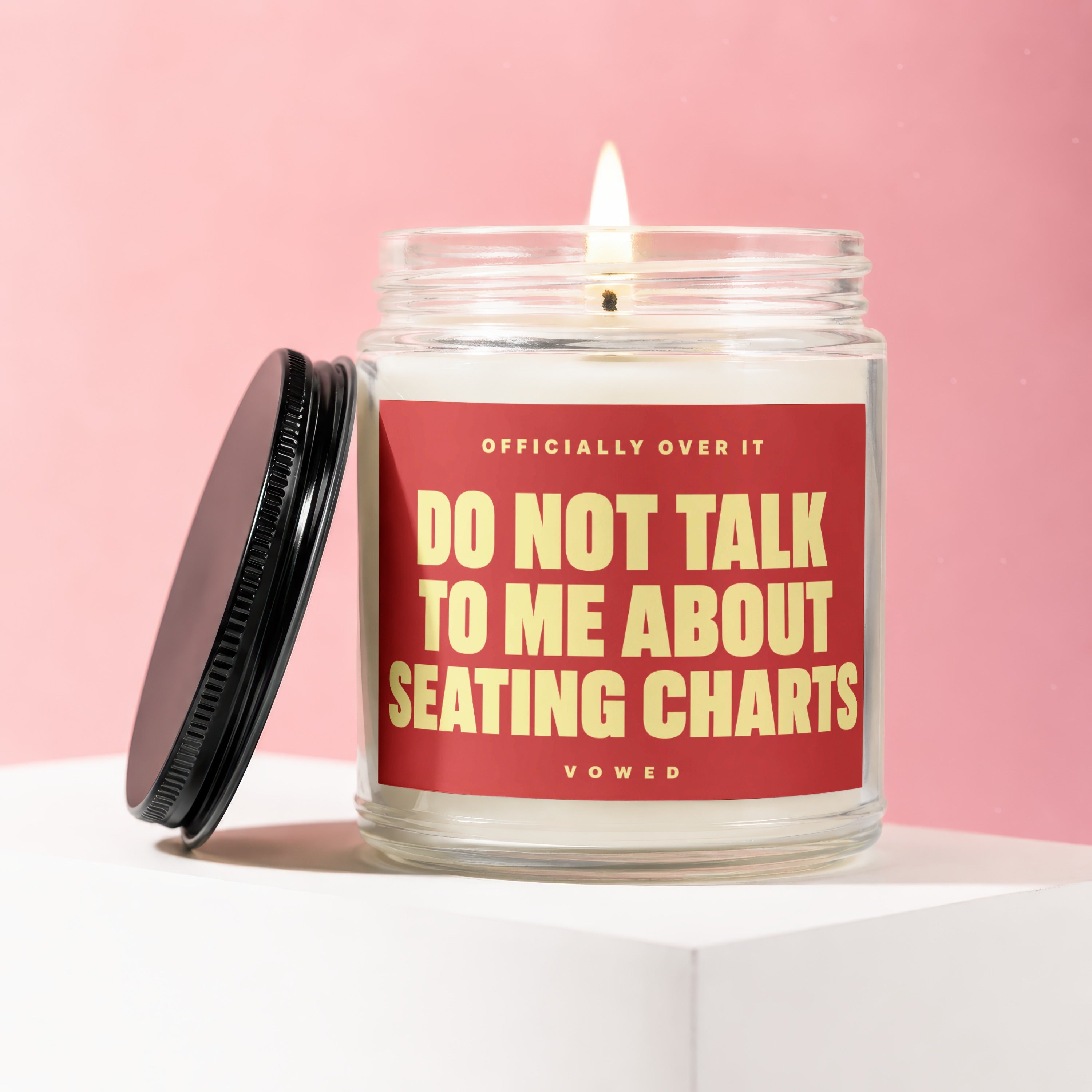 Glass candle with red label saying "Do Not Talk To Me About Seating Charts"