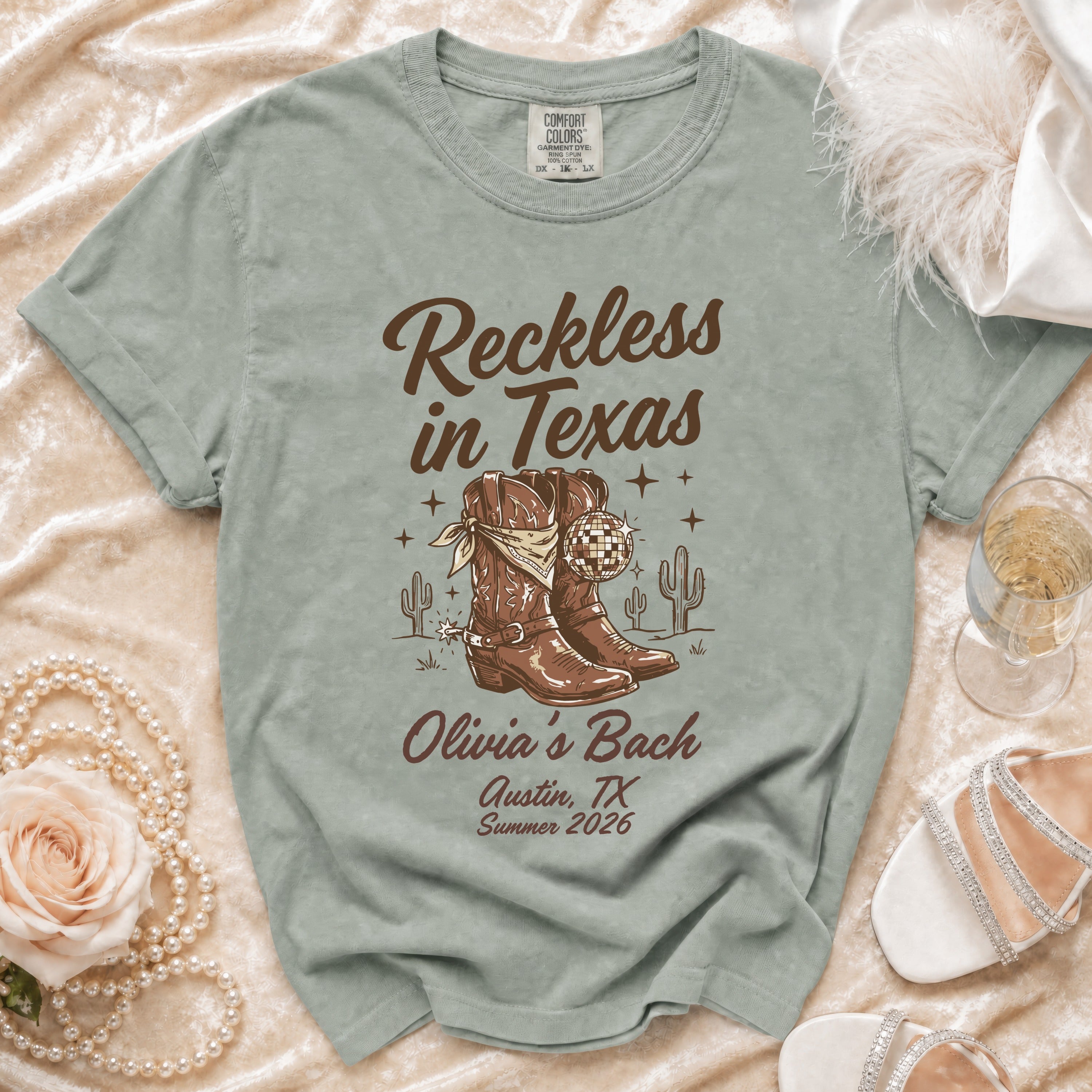 Comfort Colors t-shirt with "Reckless in Texas Olivia's Bach" design.