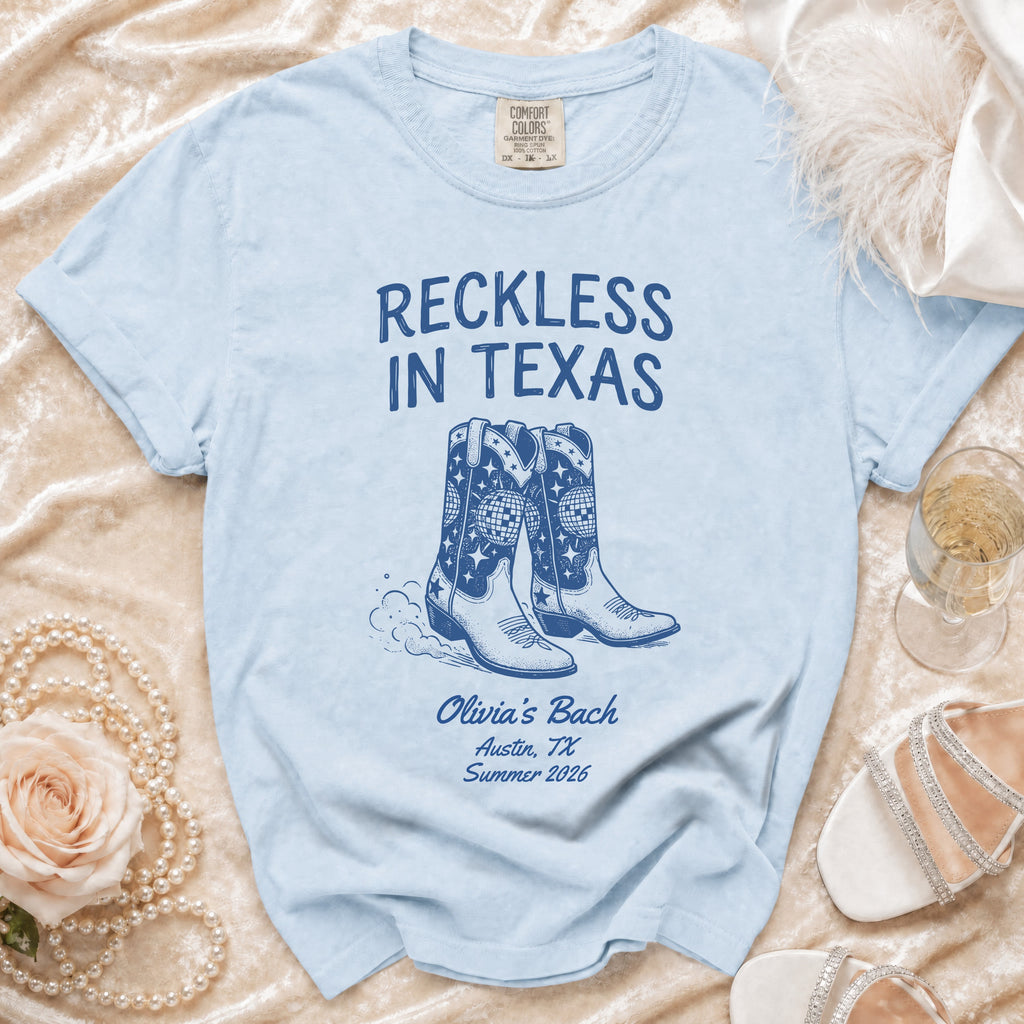 Light blue t-shirt with "Reckless in Texas" and cowboy boots.