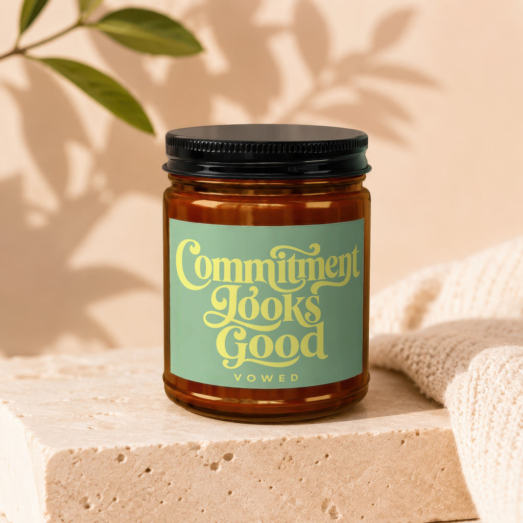 Amber jar candle with a green label reading "Commitment Looks Good" and "VOWED".