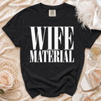 Black t-shirt with "WIFE MATERIAL" printed in white text.