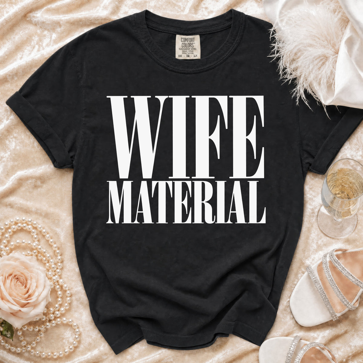 Black t-shirt with "WIFE MATERIAL" printed in white text.
