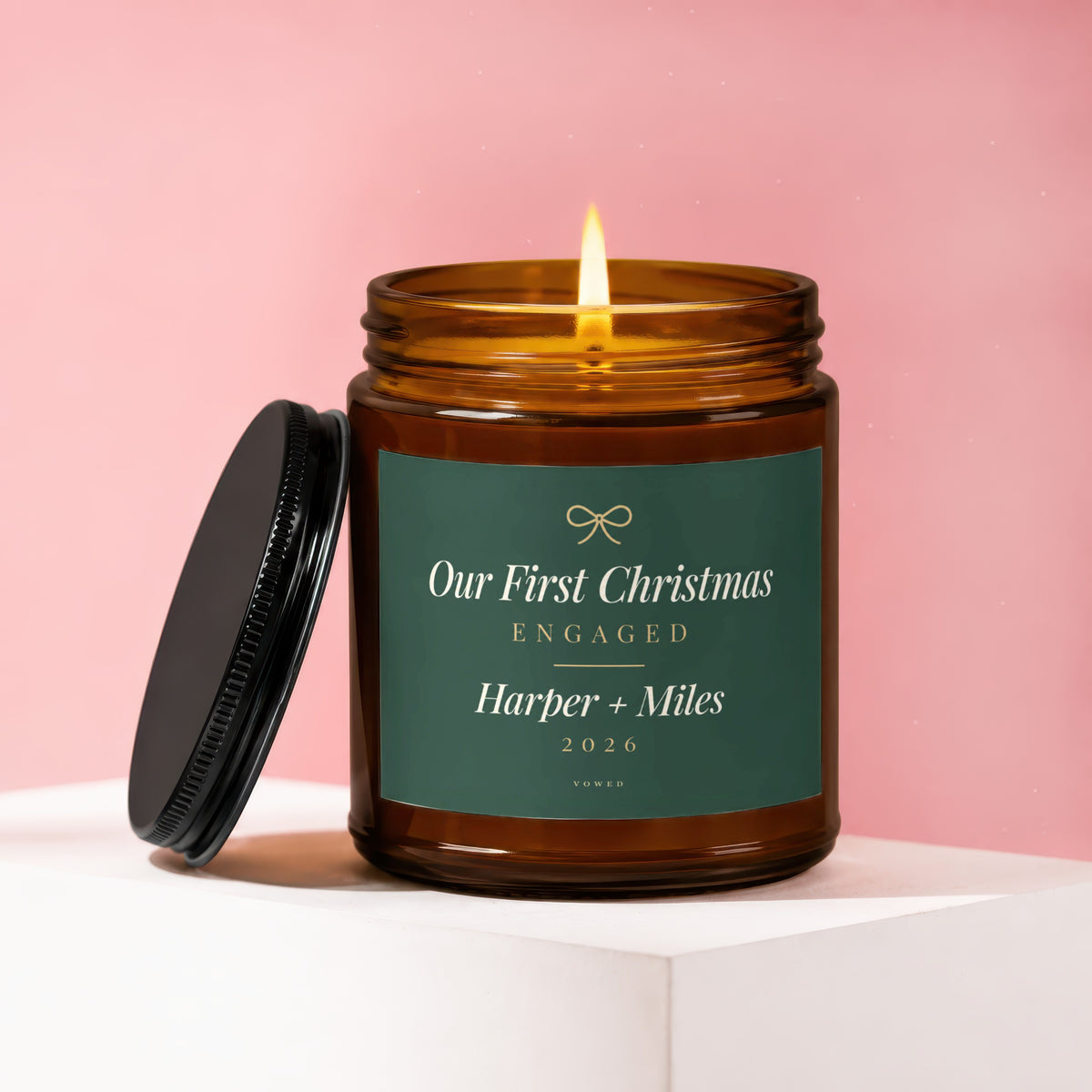 Amber candle with lit wick, "Our First Christmas Engaged Harper + Miles 2026 Vowed" label.