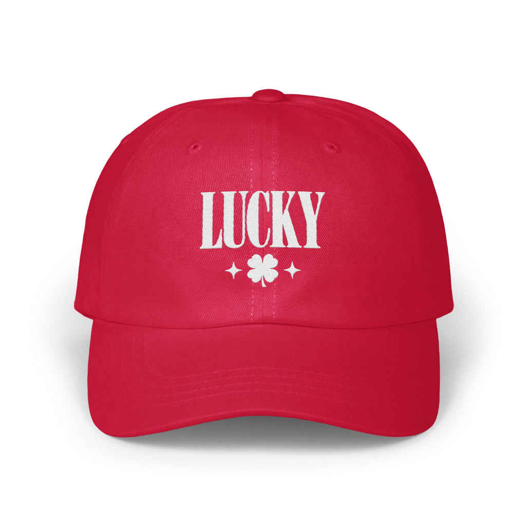 A red baseball cap with white embroidered text reading LUCKY above a four-leaf clover and two small stars.