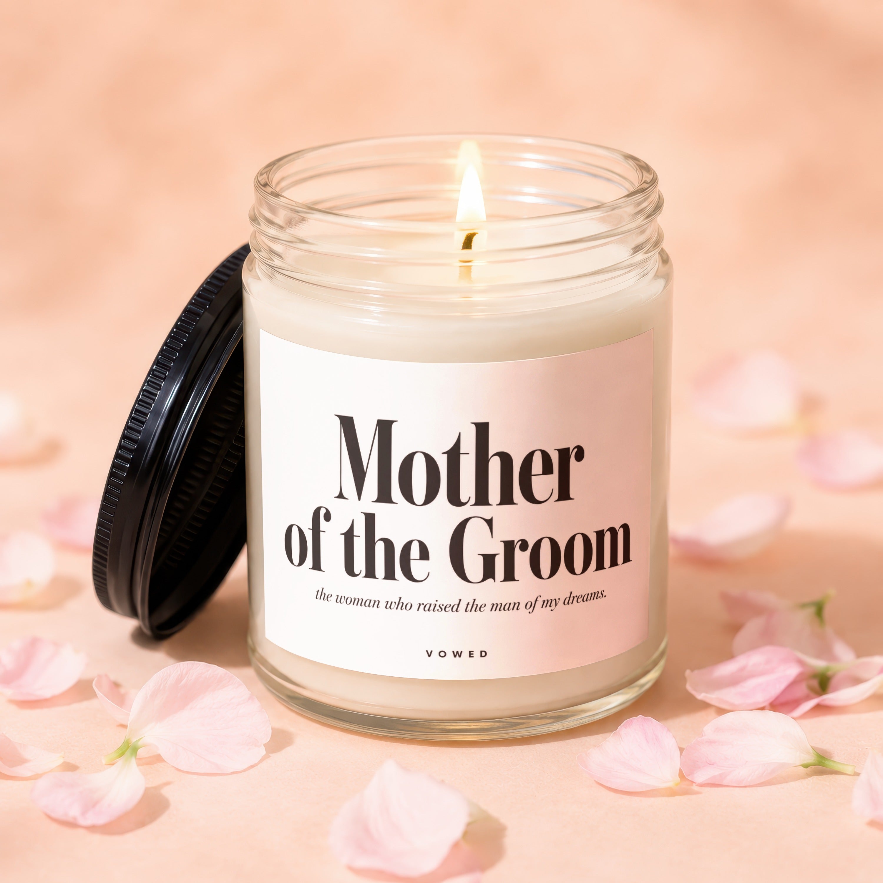 Mother of the Groom candle with lit flame and pink petals.