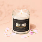 Glass jar candle with "Bride Mode Fully Activated" label, surrounded by pink petals.