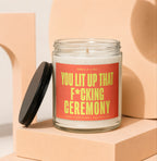 Scented candle with red label stating "You lit up that f*cking ceremony."
