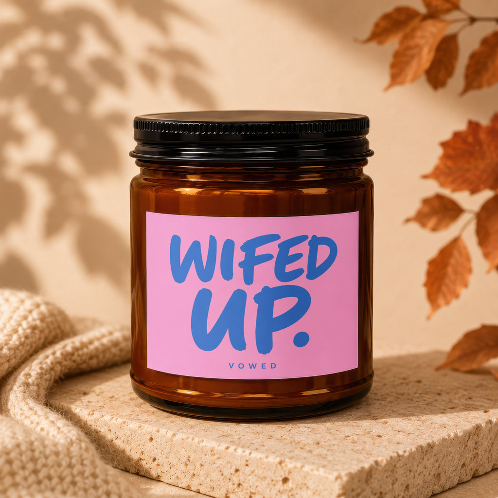 Brown glass jar candle with pink label that says "WIFED UP." VOWED.