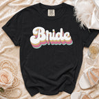 Black t-shirt with retro "Bride" text graphic with pastel layers.