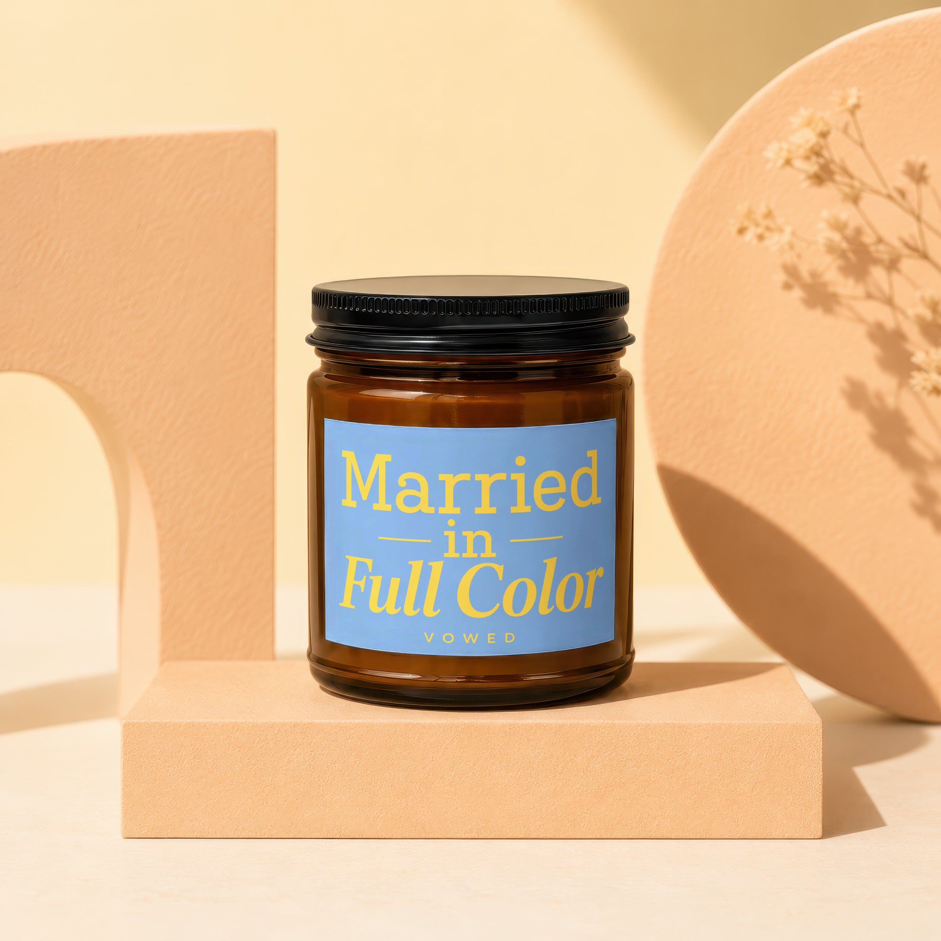 Amber jar candle with blue label saying "Married in Full Color VOWED".
