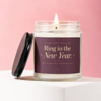 Glass jar candle with lid off, labeled "Ring in the New Year."