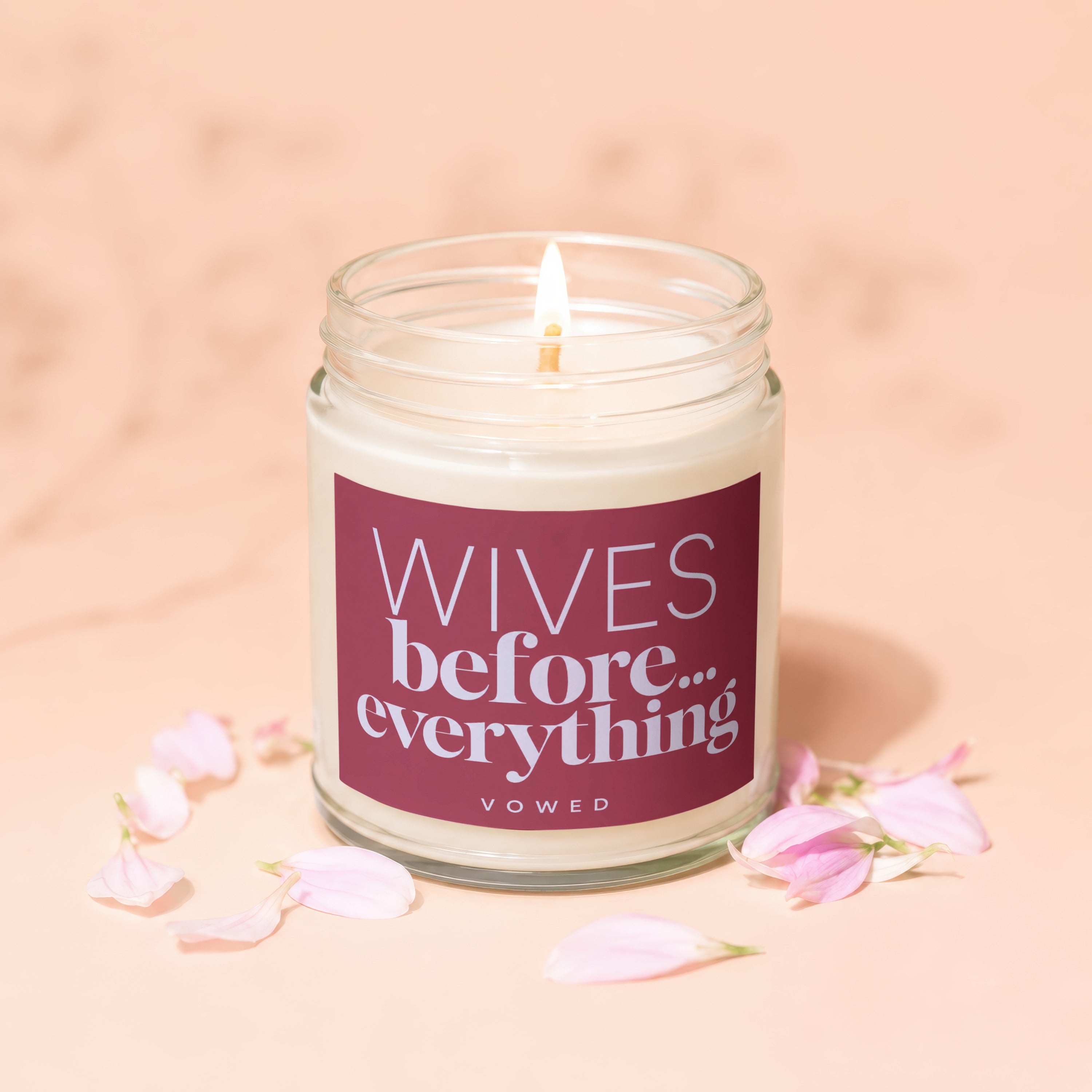 Candle with text "Wives before... everything VOWED" surrounded by pink petals.