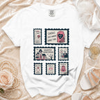 White t-shirt with postage stamp graphics featuring spooky bride, haunted house, and wedding-themed phrases.