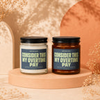 Two candles, one clear and one amber, with labels reading "Invoice: Consider This My Overtime Pay".