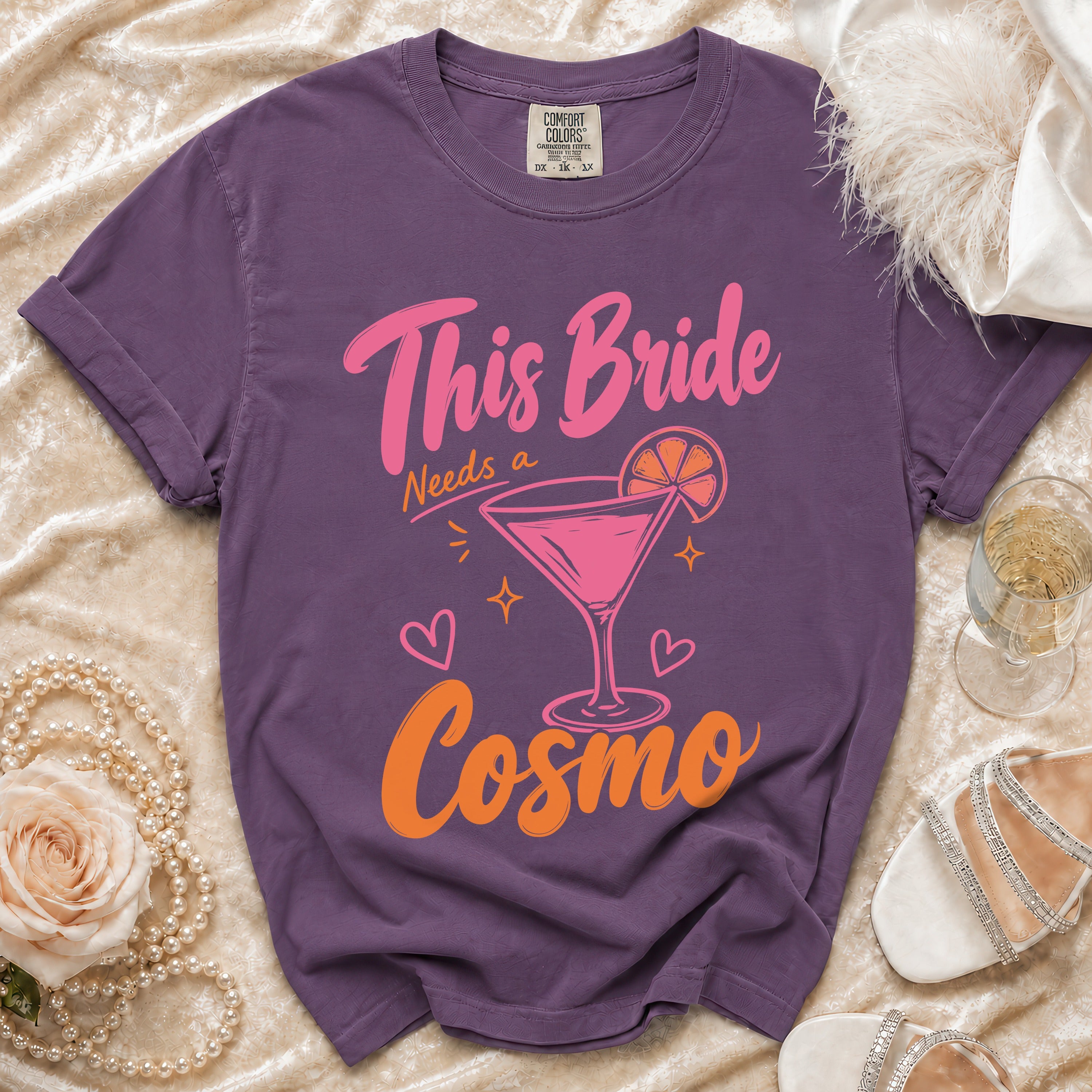 Purple t-shirt with "This Bride Needs a Cosmo" graphic and a martini glass.