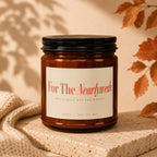 Amber glass soy wax candle labeled "For The Nearlyweds" with leaf and knit accents.