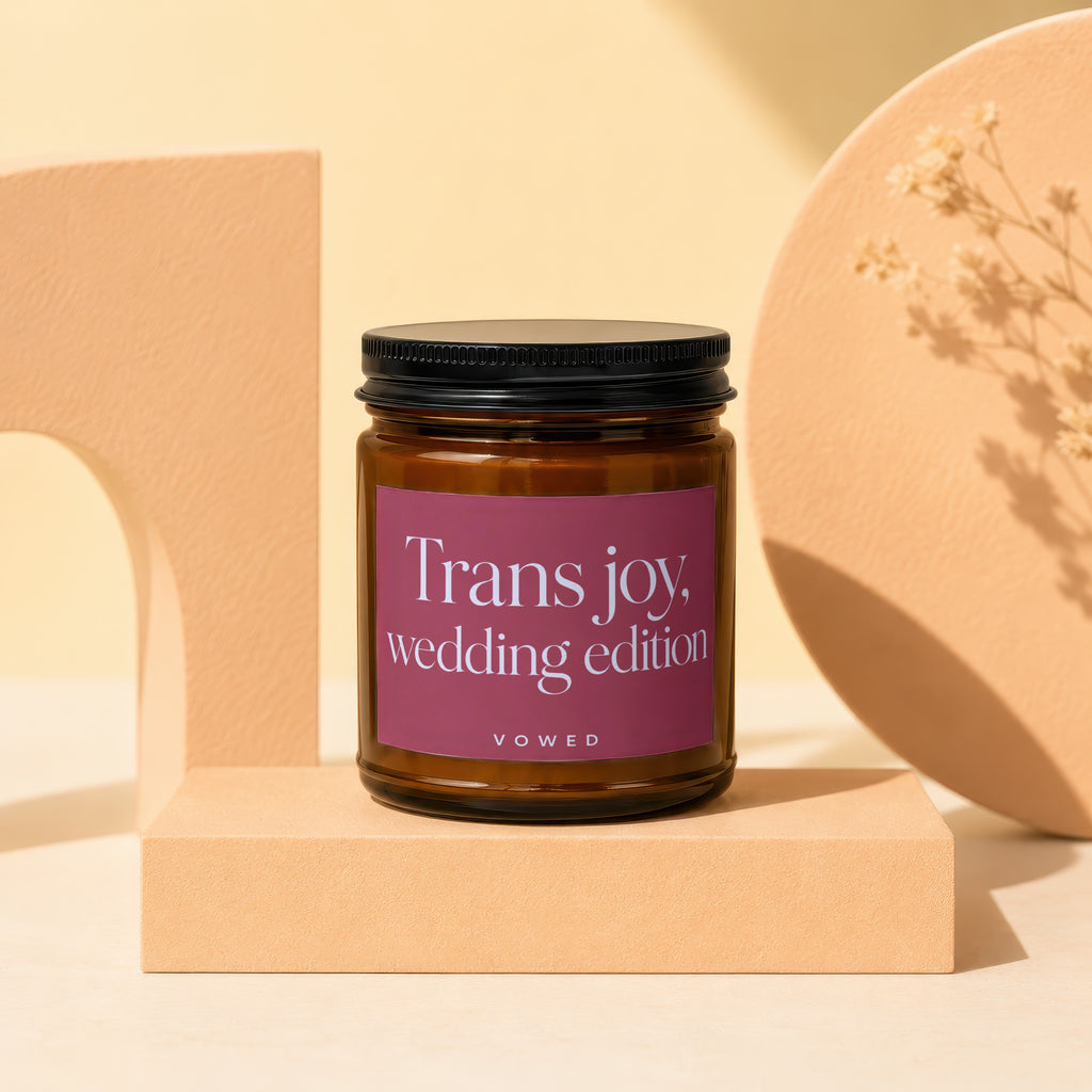 Amber glass candle with maroon label saying "Trans joy, wedding edition".
