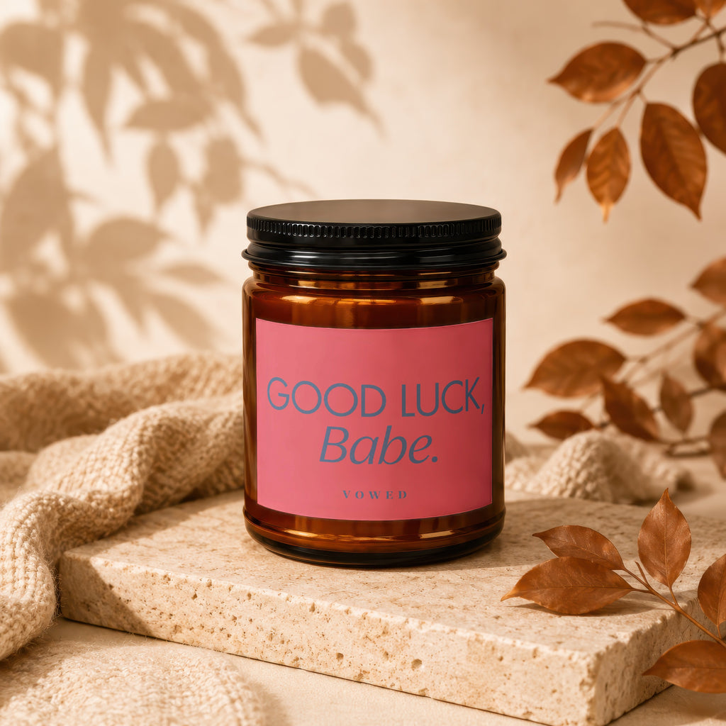 Candle with pink label reading "GOOD LUCK, Babe.", VOWED.