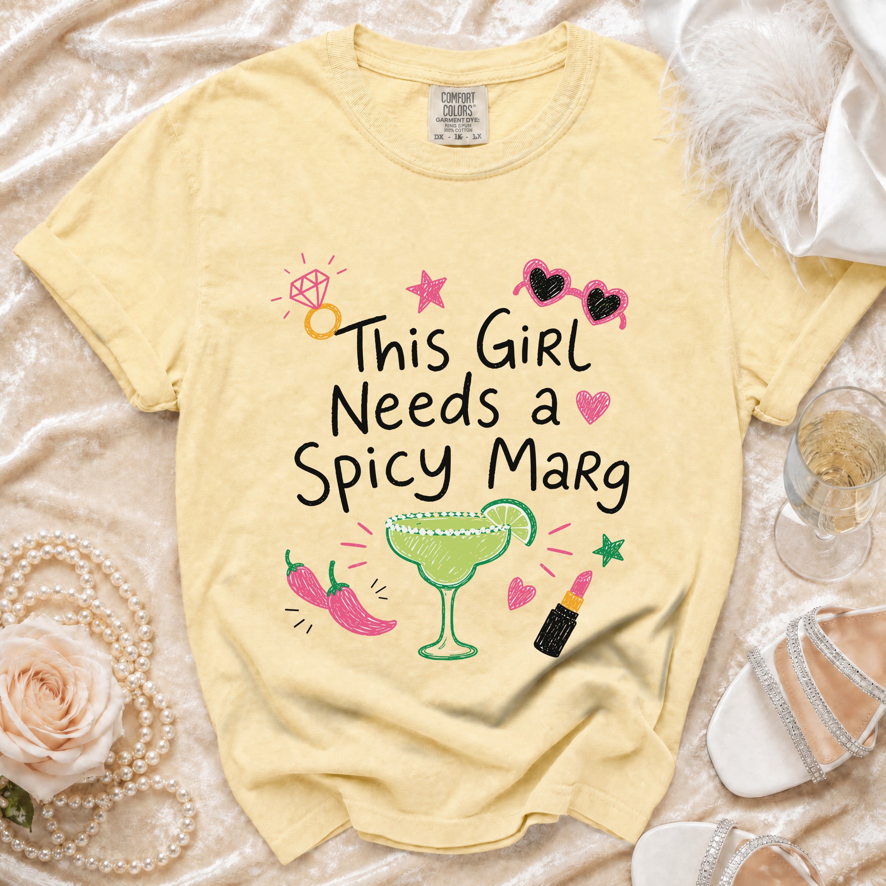 Yellow t-shirt with "This Girl Needs a Spicy Marg" and graphic elements.