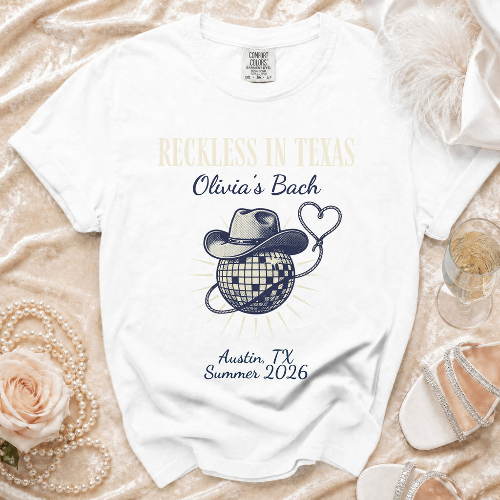White t-shirt with "Reckless in Texas Olivia's Bach Austin, TX Summer 2026" design.