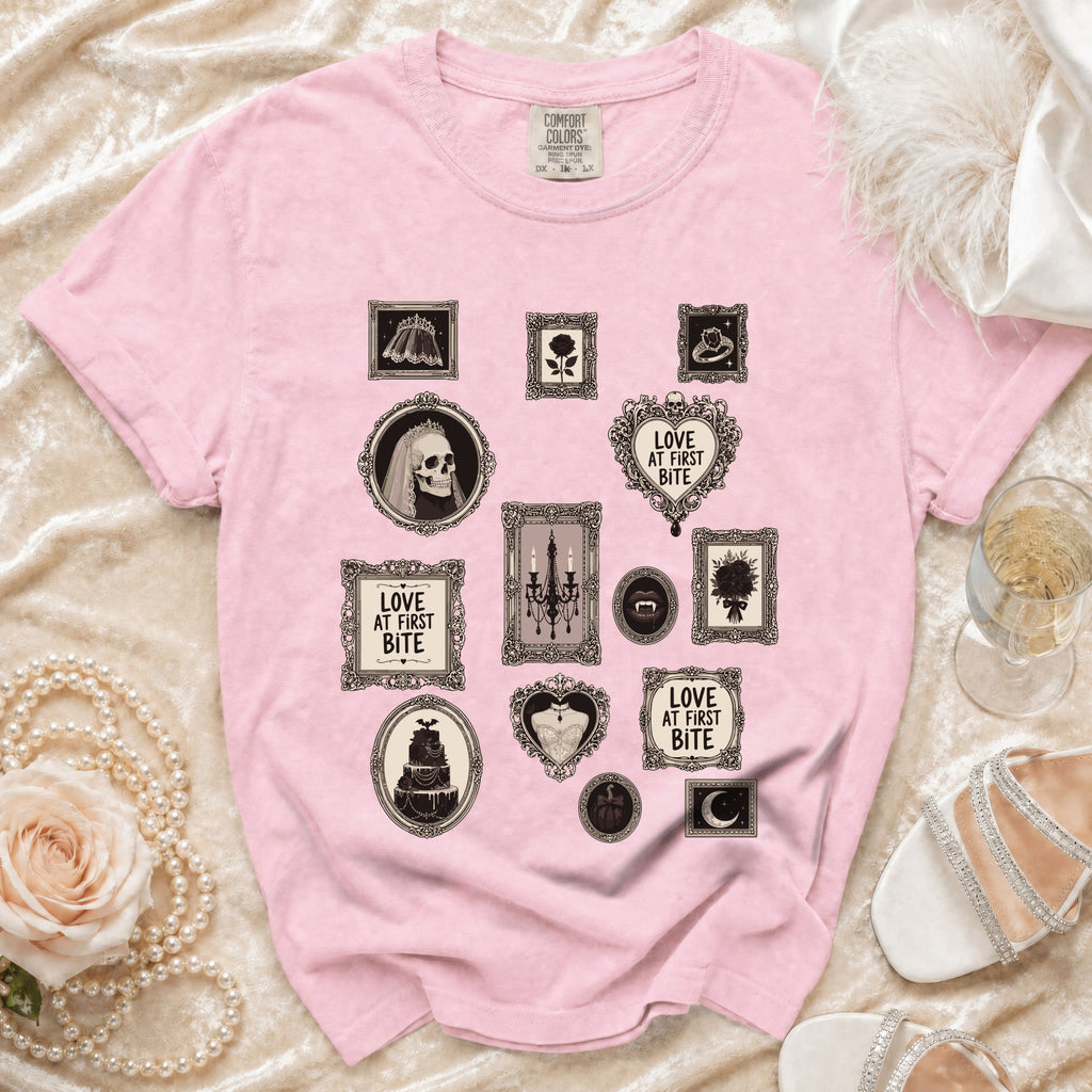 Pink t-shirt with framed gothic-themed prints including a skull, cake, and text.