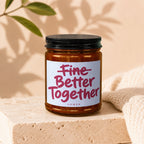 Amber glass candle with white label reading "Fine Better Together" and "vowed".
