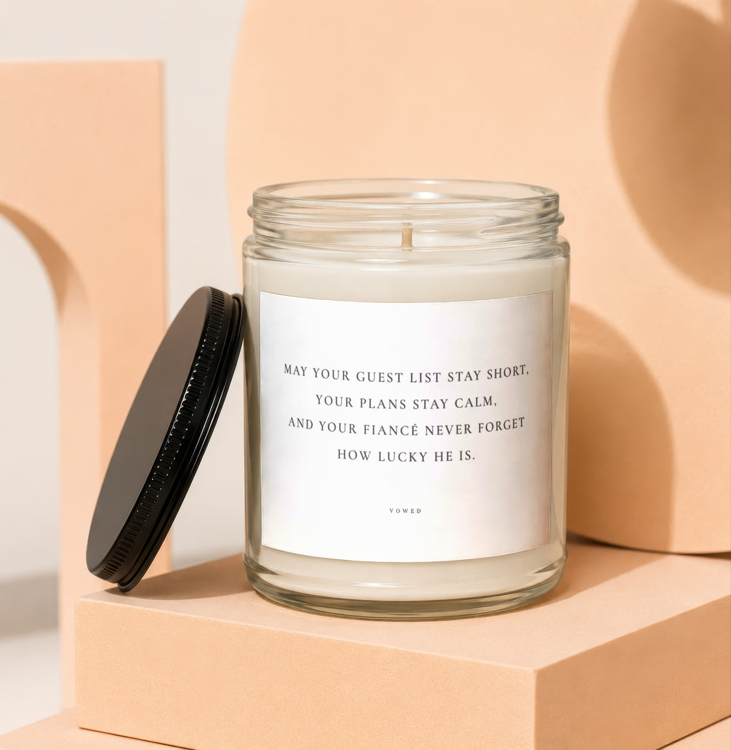Candle with quote "May your guest list stay short. Your plans stay calm. And your fiancé never forget how lucky he is. Vowed."