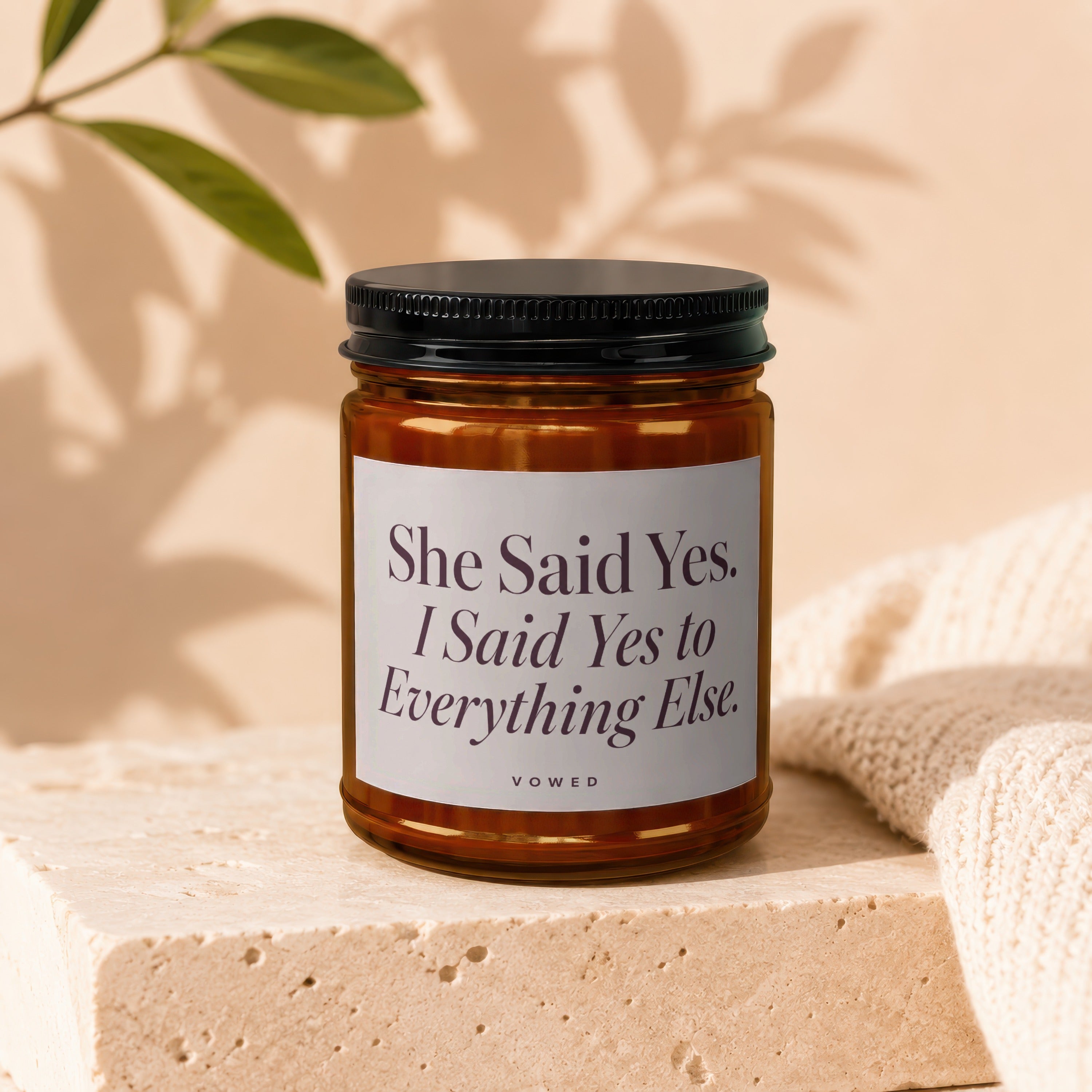 Amber candle with black lid in a square glass jar labeled "She Said Yes. I Said Yes to Everything Else."