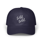 Dark blue baseball cap with white cursive embroidered text reading Wild Wild on the front.