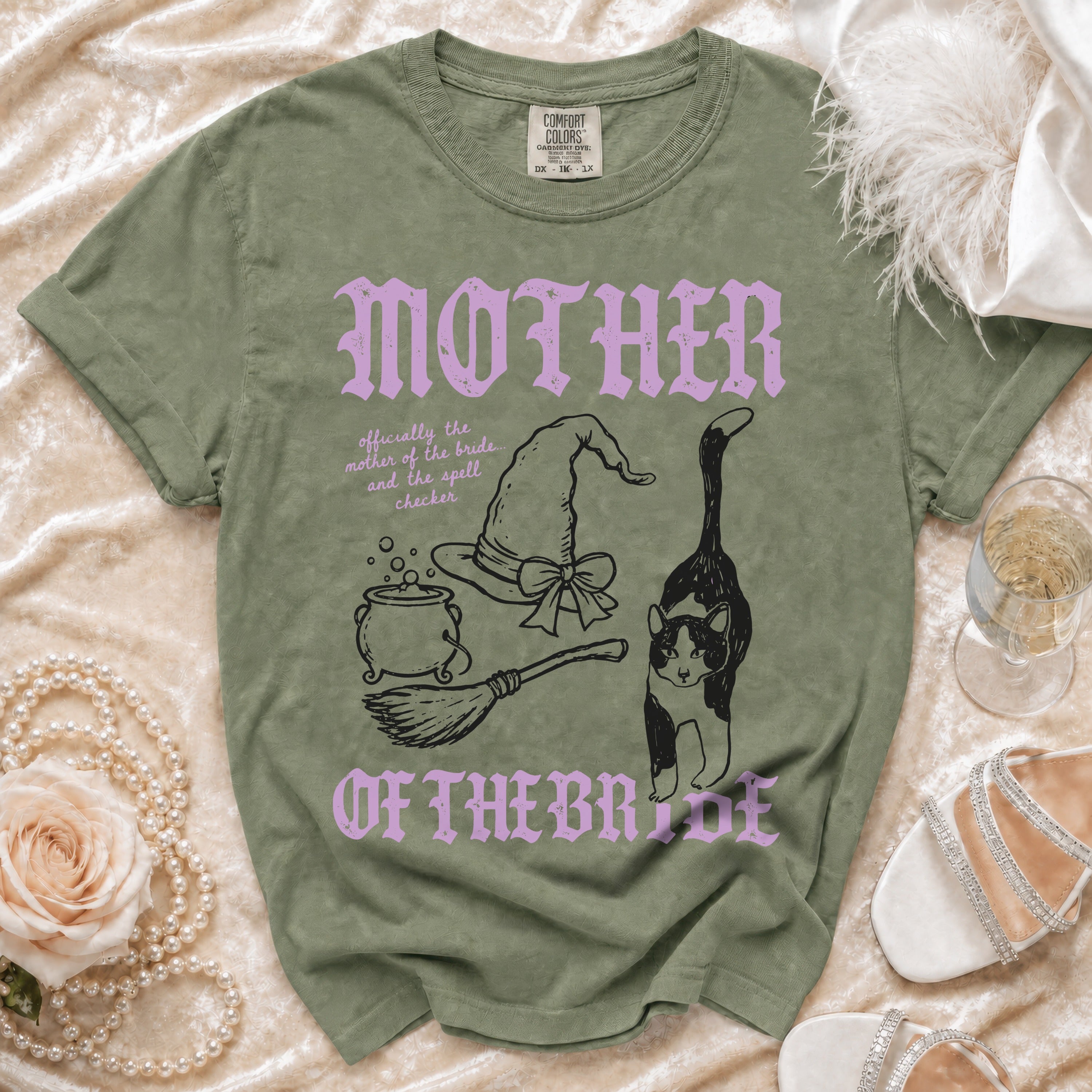 Green t-shirt with "Mother of the Bride" text, witch hat, cauldron, broom, and cat.